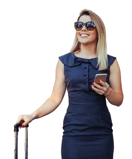 Voyageuse avec des lunettes de soleil tenant un téléphone et la poignée d’une valise.